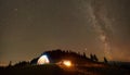 Friends resting beside camp, campfire under night starry sky Royalty Free Stock Photo