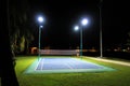 An empty tennis court at night, lit by bright lights Royalty Free Stock Photo