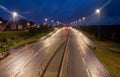 Night time dual carriageway in UK with LED street lighting and wet roads