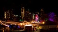 Night time view of a holiday carnival in front of the skyline of downtown Austin, Texas