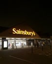 Night time view of Sainsbury logo and customer entrance