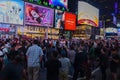 At night, Times Square bursts with activity as crowds wander along Broadway. Royalty Free Stock Photo