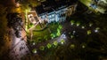 A night top view of a resort cafe or a restaurant with sunshade umbrellas, tables and chairs, empty bar surrounded by