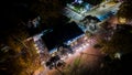 A night top view of a resort cafe or a restaurant with sunshade umbrellas, tables and chairs, empty bar surrounded by