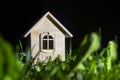 night. A toy house made of wood stands on the green grass. Close-up Royalty Free Stock Photo