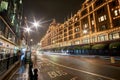 Night traffic and street scenery in a typical rainy day in United kingdom near Harrods Department Store in London. Night urban Royalty Free Stock Photo