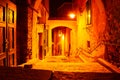 Night urban scene from a ghost tour. Red/yellow street lights in a narrow passage with stairs. No people, spooky, silent mood Royalty Free Stock Photo