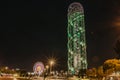 Night view of Batumi, Georgia.Colourful ferris wheel at night.Big carousel night fun. Ferris wheel and rollercoaster in motion. Royalty Free Stock Photo