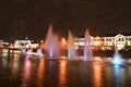 Night view of the beautiful multi-colored floating fountains on the river along the street