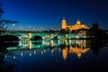 Night view of the Cathedral of Salamanca with Enrique Esteban bridge lit foreground and reflections in the Tormes river, Salamanca