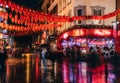 London, UK/Europe; 20/12/2019: Night view of a Chinatown street with red chinese lanterns, neon sign and wet floor in the district Royalty Free Stock Photo