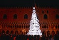 Night view of the Christmas Tree with beautiful light in front of Doge`s palace in San Marco Square full of people Royalty Free Stock Photo