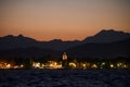 Night view of the city with its waterfront, and mountain silhouettes in the background Royalty Free Stock Photo