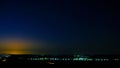 Night view of a city, sky full of stars and sunlight at sunset