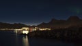 Night view of the coast of AustvÃÂ¥gÃÂ¸ya, Lofoten, Norway with traditional stockfish drying racks and illuminated town of SvolvÃÂ¦r.