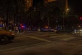 Night view of Collins Avenue with many police cars with flashing lights.