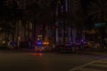 Night view of Collins Avenue with multiple police cars their flashing lights illuminating ensuring safety and order.