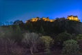 Night view of Edinburgh Castle with lights on a hill in Edinburgh, Scotland behind trees Royalty Free Stock Photo