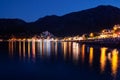 Night view of the embankment and promenade in the light of street lights and lighting of restaurants. small town Royalty Free Stock Photo