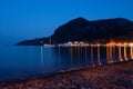 Night view of the embankment and promenade in the light of street lights and lighting of restaurants. small town Royalty Free Stock Photo