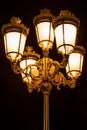 Night view of five beautiful decorative bronze street lights together on a lampost outdoors