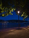 Night view of flooded river promenade on Rhine riverbank with high water level illuminated by lantern in Koblenz center.