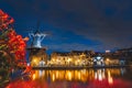 Night view of Haarlem city centre with the illuminated historic mill and buildings. Typical Dutch architecture