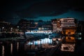 Night view of a harbor in Wroclaw, Poland with buildings and boats on the water under street lights