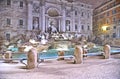 Night view with heavy snowfall on Trevi Fountain square, the largest Baroque fountain in the city and one of the most famous foun