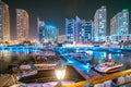 Night view of high-rise buildings of residential district in Dubai Marina And Yachts Moored Near Pier In Evening Night Royalty Free Stock Photo