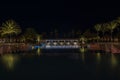 Night view of the hotel grounds with an open pool, a bar, and palm trees reflecting in the water. Royalty Free Stock Photo