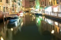 Night view of illuminated old buildings, floating boats and light reflections in canal water in Venice, Italy Royalty Free Stock Photo