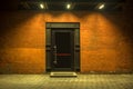 Night view. Industrial building. Large doors in a red brick building. The entrance to the warehouse. Facade Royalty Free Stock Photo