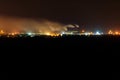 Night view of industrial district of the city and smoke pipes of factory