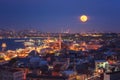 Night view of Istanbul, scenic cityscape with buildings in lights, bridge, bay and blue sky with full moon, Turkey Royalty Free Stock Photo