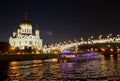 Night view of Moscow Christ the Savior Cathedral, Patriarshy Bridge, embankment and Moskva river with pleasure boat