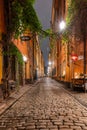 Night view of narrow illuminated empty street in the historic Old Town in Stockholm Sweden. Royalty Free Stock Photo