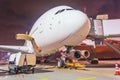 Night view of nose and cockpit a large plane during pre-flight maintenance service Royalty Free Stock Photo