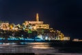 Night view of Old Jaffa city, old port and coastal line of Tel Aviv under sunset and lots of tourists are swimming and surfing at