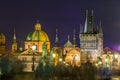 Night view of Old Town Bridge Tower and background of Church of St Francis Seraph at the bank of River Vltava, view from the