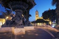 Night view of the Ornamental Pile, -water fountain with bronze sculptures in the background illuminated Cathedral of