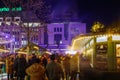 Night view of people on street around stalls of Christmas market