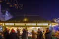 Night view of people on street around stalls of Christmas market