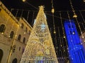 A night view of Piazza del Comune during Christmas time, featuring a large illuminated tree Royalty Free Stock Photo