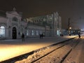 Night view of the railway station in the city of Cherepovets, Russia. People cross the rails in the light of lanterns