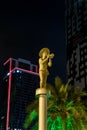 Night view of the statue of a boy playing on the forge and standing on a high pillar on the Batumi Boulevard Fountains in Batumi