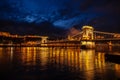 Night View Of Szechenyi Bridge. Famous Chain Bridge Of Budapest. Beautiful lighting and reflection in the Danube River. Royalty Free Stock Photo