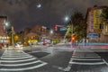 Night view to crossing bergen street in New York with blurred cars and people and moon at sky