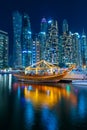 Night view to Dubai Marina panorama, and traditional wooden UAE boat. Luxury skyscrapers represent modern Dubai. Amazing colors. Royalty Free Stock Photo