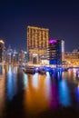 Night view to Dubai Marina skyline, reveals Pier 7 and boats. Luxury destination for tourists and residents. Royalty Free Stock Photo